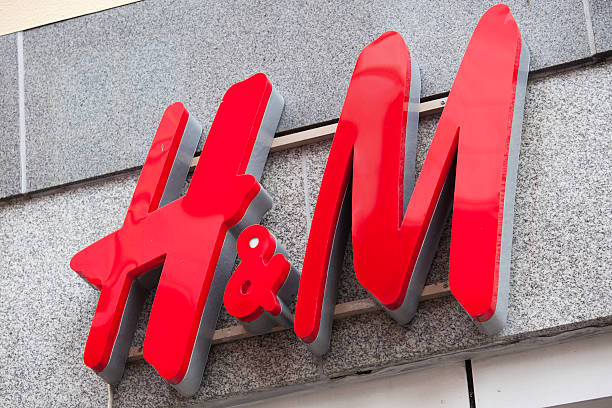 H&M logo "Aalborg, Denmark - July 16, 2011: H&amp;M (Hennes &amp; Mauritz) logo outside H&amp;M\'s store in Aalborg, Denmark. H&amp;M is a Swedish retail clothing company with over 2,300 stores in 41 countries and as of 2011 employed around 87,000 people." h and m stock pictures, royalty-free photos & images