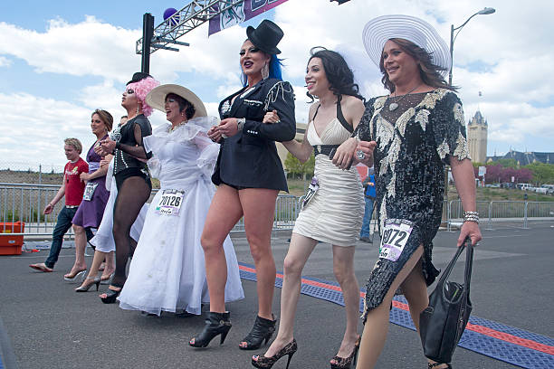 Drag queens parading. "Spokane, Washington - May 6, 2012.  Local drag queens walk the entire 7 1/2 miles in high heels at the bloomsday race." bloomsday stock pictures, royalty-free photos & images