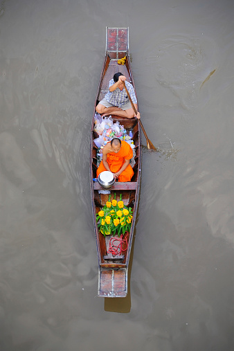 Samudsongkarm, Thailand - September 27, 2009: Monk rows a boat to receive food in the morning at Amphawa floating market in Samudsongkarm, Thailand.
