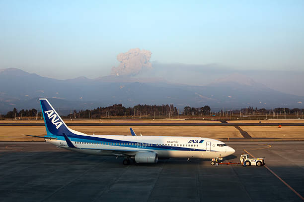 Airplane  at Kagoshima, Japan  airport with Shinmoedake volcano erupting stock photo