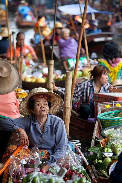 vendedor de frutas no mercado flutuante de damnoen saduak, tailândia. - editorial in a row national landmark famous place imagens e fotografias de stock