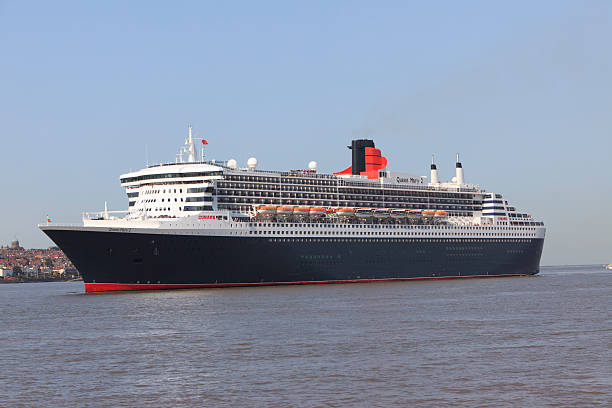 Queen Mary 2 "LiverpoolUnited Kingdom - September 15, 2011: Cunard's Ocean Liner Queen Mary 2 in the River Mersey approaching Liverpool.The ocean liner can carry 3056 passengers and 1253 crew and is 1132 feet long.She weighs 151400 tons and has 17 decks .Built for the Southampton to New York transatlantic trade,she also does a round the world cruise once a year.Liverpool is the historic home of Cunard." round the world travel stock pictures, royalty-free photos & images