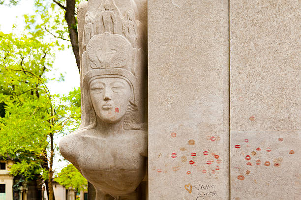 Oscar Wilde's Grave, Paris "Paris, France- July 16, 2012: Side view of Oscar Wilde's tomb in the Pere Lachaise Cemetery in Paris, France. The tomb was designed by Sir Jacob Epstein in the Modernist style. It is covered with kisses and graffiti by fans." oscar wilde stock pictures, royalty-free photos & images