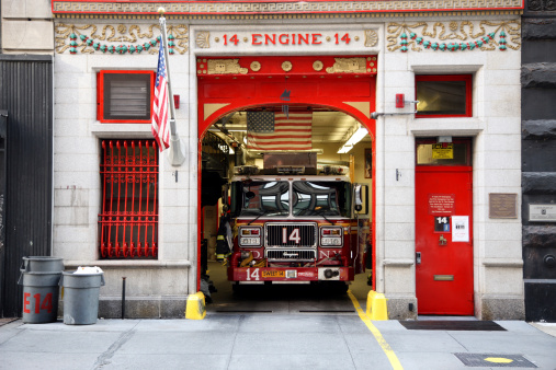 New York City, NY, USA - August 20, 2022: The firefighter is backing up the firetruck into the Hook and Ladder Company 8 fire station in New York City, NY, USA, a popular tourist attraction.