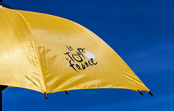 Parasol Tour de France "Paris,France,July 22,2012: Image of a yellow parasol with the official logo of Le Tour de France against a blue sky.During the Tour's days a lot of souvenirs are sold." tour de france stock pictures, royalty-free photos & images