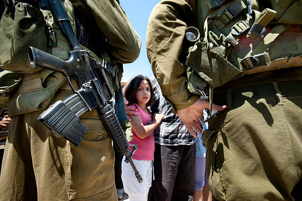 West Bank Protest "Al-Walaja, Occupied Palestinian Territories - August 27, 2011: A Palestinian girl confronts Israeli soldiers in a protest against the encirclement of the West Bank town of Al-Walaja by the Israeli separation barrier." palestinian territories stock pictures, royalty-free photos & images