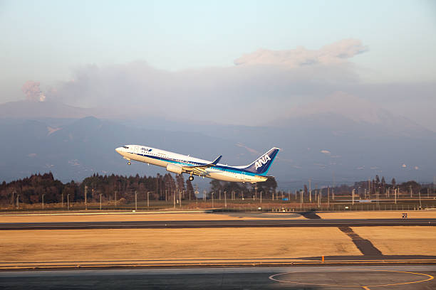 ANA airplane takes off with Shinmoedake volcano erupting in background stock photo