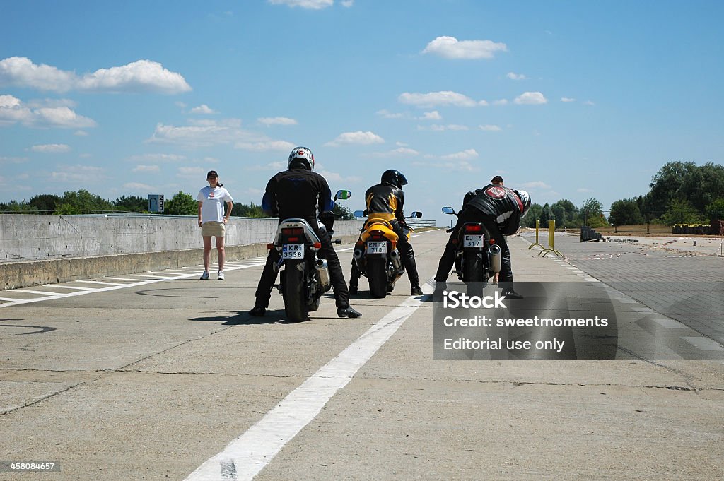 ready to go Poland, Poznan - July 04, 2005: Thre young motorcyclists, preper for driving on the race track, during the course of improving driving skills with motorcycle.  12 O'Clock Stock Photo