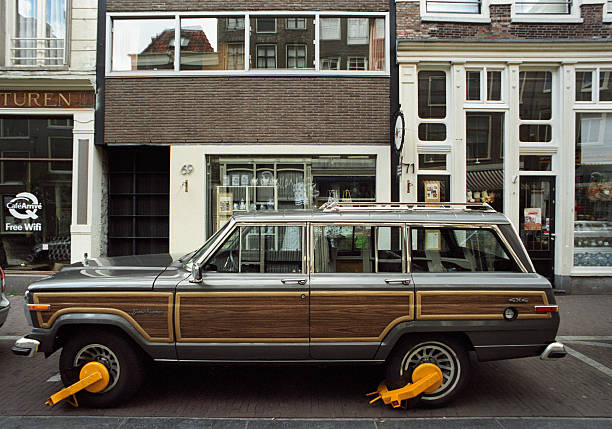 Jeep Grand Wagoneer clamped in Amsterdam Amsterdam, The Netherlands - May 15, 2011: A Jeep Grand Wagoneer is clamped in a central street in Amsterdam. car boot stock pictures, royalty-free photos & images