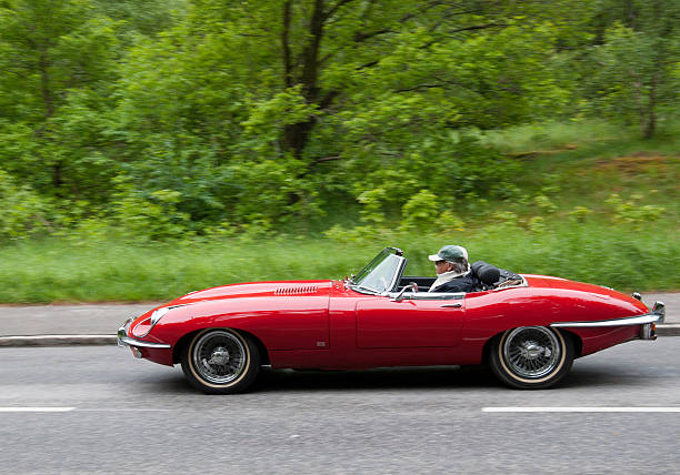 Red Jaguar E-type "Stockholm, Sweden - june 03,2012:A fully restored Jaguar E-type, in a classic car cavalcade around the small island DjurgAYrden on the public road in Stockholm Sweden" djurgarden photos stock pictures, royalty-free photos & images