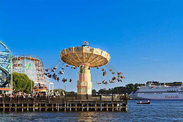 Amusement park in Stockholm "Stockholm, Sweden - August 4, 2012: Grona Lund, Amusement park in Stockholm seen from the sea. Merry-go-round and rooler costers of different kinds can be seen. A ferry crossing from old city is just arriving." djurgarden photos stock pictures, royalty-free photos & images
