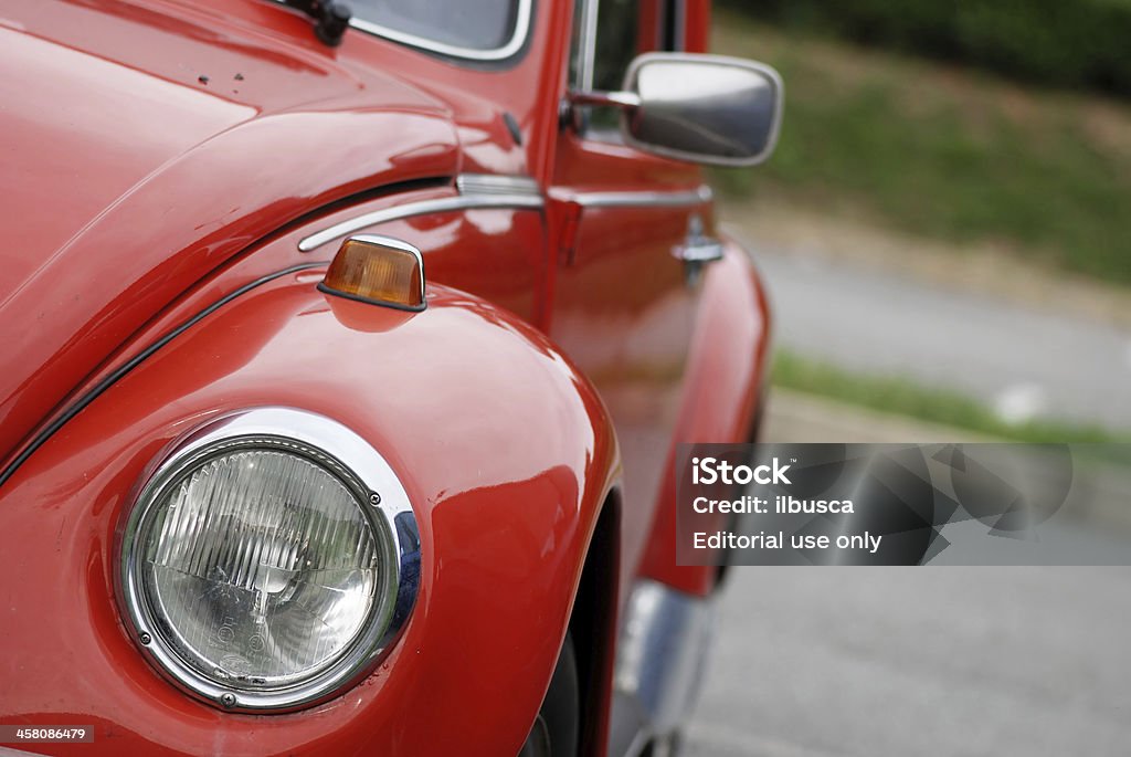 Old red Volkswagen Beetle in the street Borgosesia, Italy - September 19, 2011: Old red Volkswagen Beetle model VW 1303 parked in a parking lot in Borgosesia, close up on front headlight. Car Stock Photo