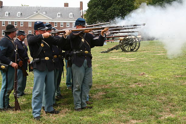 Civil War Union Soldiers Firing Rifles New York City,USA-August 13,2011:men costumed as union soldiers are seen firing rifles in a civil war enactment on Governor\'s Island. civil war enactment stock pictures, royalty-free photos & images