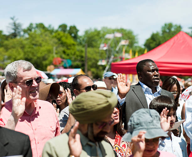 Canada Day Swearing-in Ceremony for New Citizens "Milton, Canada - July 1, 2011: New Canadian Citizens are sworn in during a Canada Day new citizenship ceremony at Milton, Ontario fairgrounds the morning of July 1st, 2011. July 1st--or ""Canada Day""--is the national day of Canada. The ceremony included new citizens who had immigrated from a  variety of regions and countries including; Afghanistan, Pakistan, India, Nigeria, Australia, Great Britain, South Africa, Iraq, and China." citizenship photos stock pictures, royalty-free photos & images