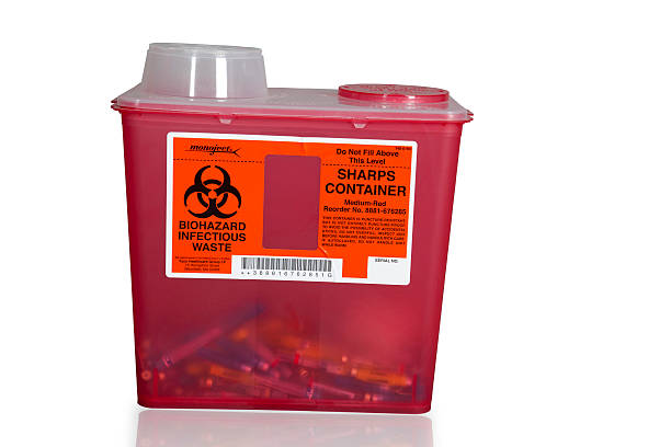 sharps container "Cinnaminson, New Jersey, USA - May 28, 2011: Sharps container for bio hazard waste containing used medical needles" container stock pictures, royalty-free photos & images