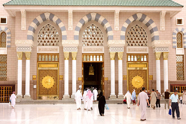 Medina, Saudi Arabia - April 16, 2011: Muslim pilgrims entering to Masjid al-Nabawi ( Prophet's Mosque ) for the noon prayer. As the final resting place of the Prophet Muhammad, it is considered the second holiest site in Islam by Muslims (the first being the Masjid al-Haram in Mecca).