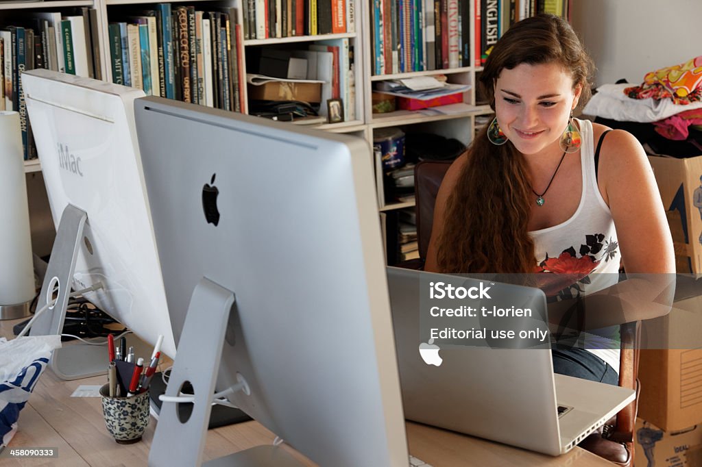 Ann Apple a day keeps ..... Copenhagen, Denmark, August 22nd, 2011. Young girl sitting in well equipped private office - smiling while she researches for her education. Home Office Stock Photo