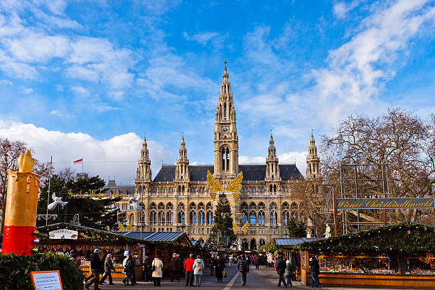 Vienna, Austria - December 13, 2010: people strolling at the Christkindlmarkt in the Rathausplatz, the most important Christmas Market among the numerous of the city. In the background stands the imposing Vienna City Hall, a beautiful example of Gothic Revival architecture.