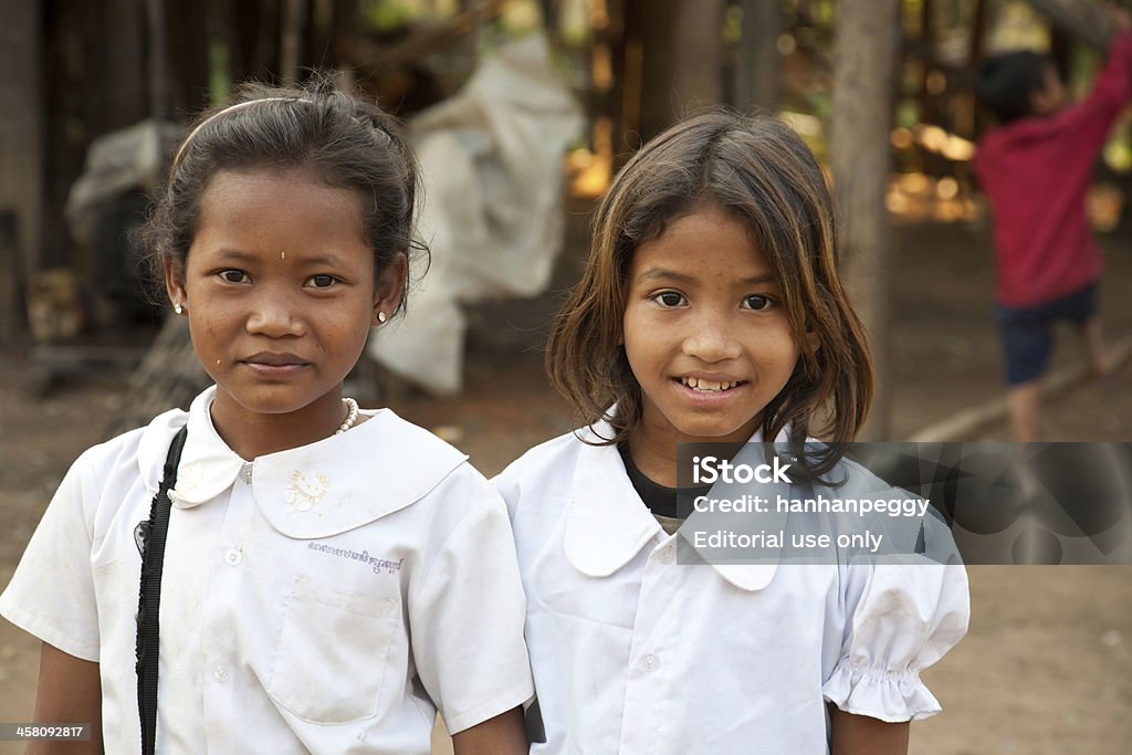 smiling girl students, Cambodia "Kom Pong Pluke, Siem Reap, Cambodia - February 3, 2011:The portrait of  two local smiling girl students  wearing school uniforms.  Kom Pong Pluke is a village which is near Tonle Sap Lake. When rainy season come, the road will be submerged. Houses just like floating on water. The village also is called floating village." Cambodia Stock Photo