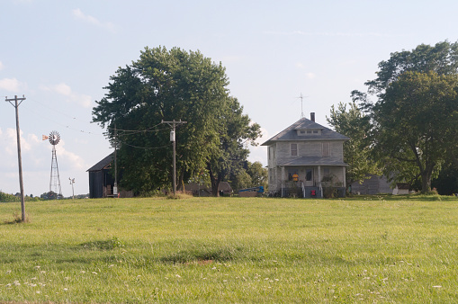 Vicinity of Yorkville, Illinois - August 7, 2011: A lone security guard stands watch on the shaded porch of an old farmhouse that will be a movie set for \\\