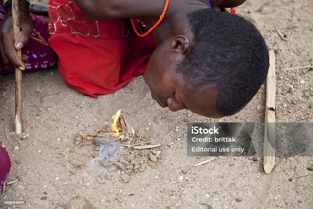Samburu uomo facendo fuoco con stick e capre Letame. - Foto stock royalty-free di Adulto