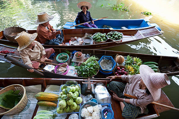 obst anbieter im schwimmender markt von damnoen saduak, thailand. - editorial in a row national landmark famous place stock-fotos und bilder