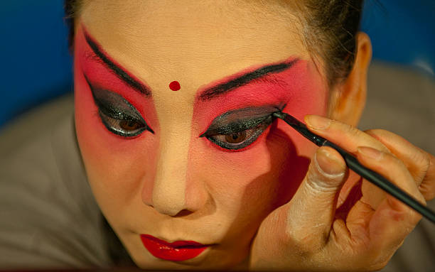 Actress making up at back stage "Chengdu, China - July 09, 2011: A Sichuan opera actress is making up at the back stage of a traditional tea house in Chengdu, China. Generally, it needs 30 - 60 minutes to complete the whole process." chinese opera makeup stock pictures, royalty-free photos & images