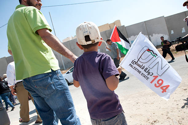 Demonstration for Palestine Statehood "Al-Walaja, Occupied Palestinian Territories - September 16, 2011: A boy carries a flag supporting Palestinian statehood during a protest in Al-Walaja, West Bank." apartheid sign stock pictures, royalty-free photos & images