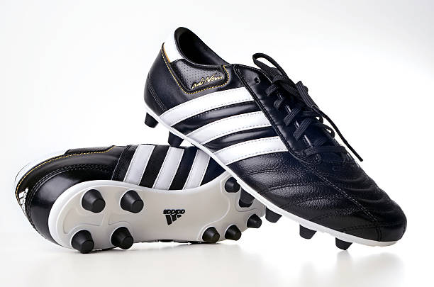 Retro outdated soccer spike boots and football. Vintage old style filtered photo
