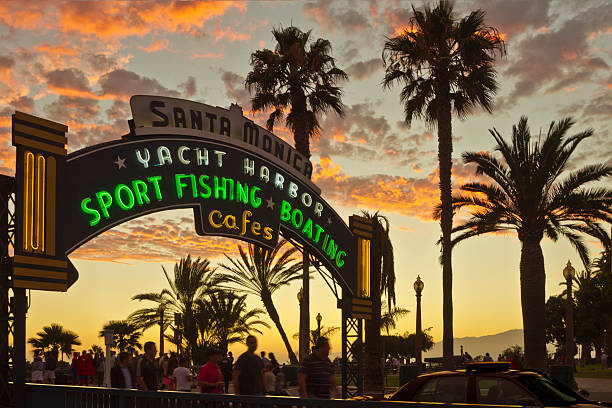 por encima de la señal de entrada al muelle de santa mónica al atardecer - santa monica pier fotos fotografías e imágenes de stock