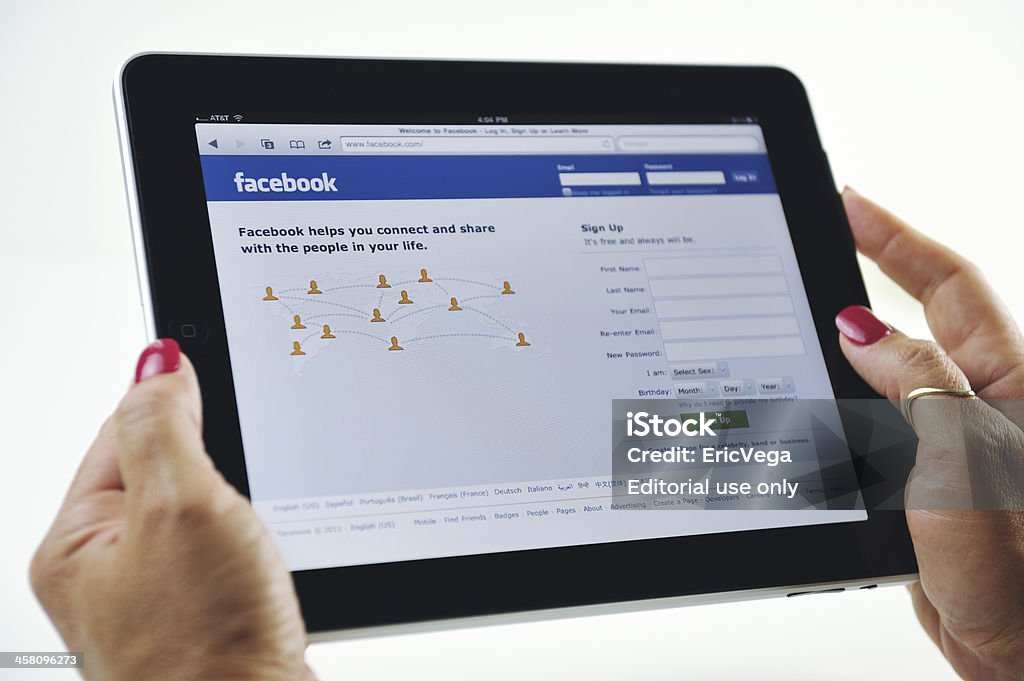 Donna che tiene un iPad visualizzando Facebook - Foto stock royalty-free di Adulto