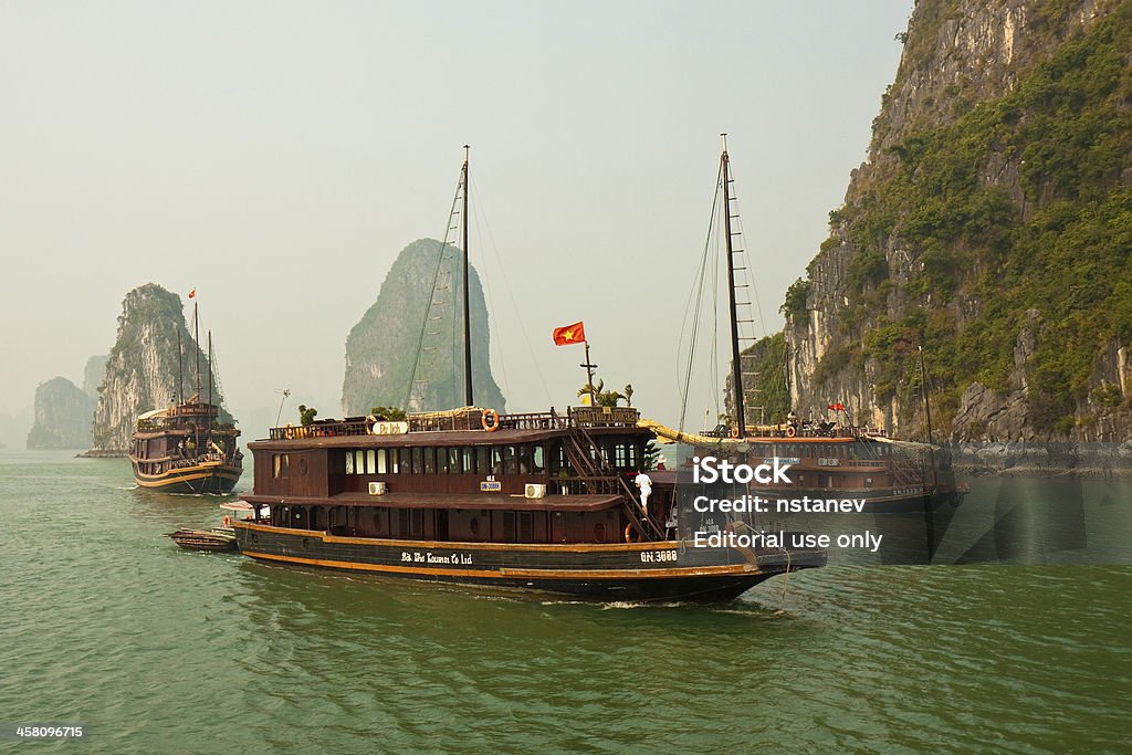 Boats in Beautiful Halong Bay "Halong Bay, Vietnam - November 30, 2009: Tourist junks navigate through the karst islands of Halong Bay (the Bay of the Descending Dragon). This UNESCO World Heritage Site is one of Vietnam\'s prime travel destinations." Hạ Long Bay Stock Photo