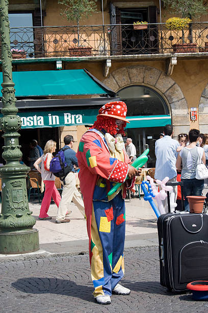 Clown in Verona blowing up balloons stock photo