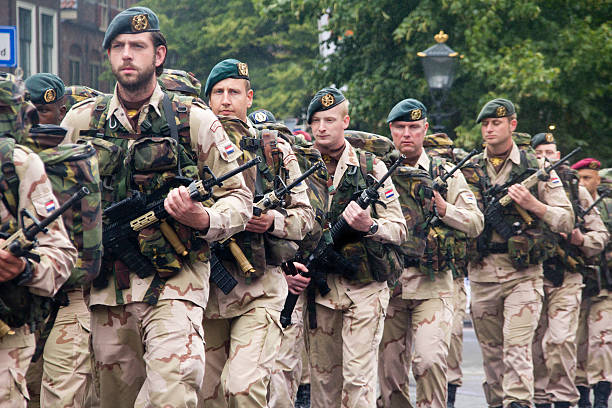 Soldiers Marching "The Hague, Holland - June 25, 2011: Soldiers with guns marching past on Veterans Day parade in The Hague, Holland on June 25, 2011" military parade stock pictures, royalty-free photos & images