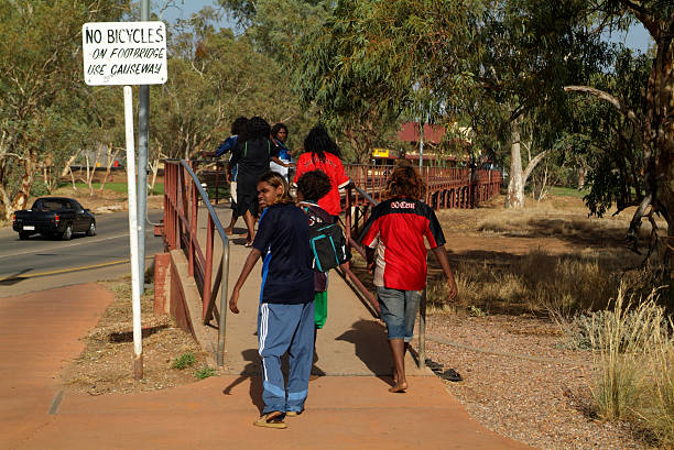 Australia, Alice Springs, "Alice Springs, Australia - February 29th 2008: Aborigines inhabitants on their way to school on the bridge over the Todd River, useally a dry creek" alice springs photos stock pictures, royalty-free photos & images