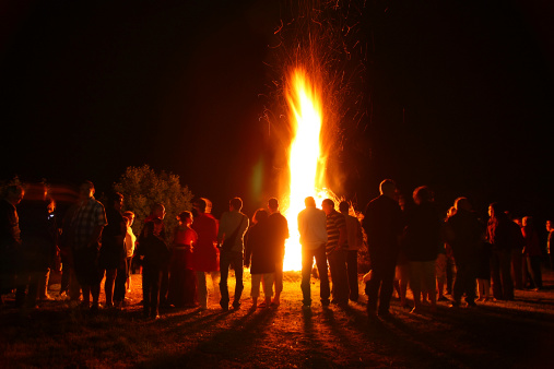 Rignat, France - June 23, 2012: back view of group of people, looking a great fire, gathered for the feast of St. John, bonfires lit on Midsummer Night