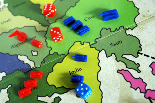 Scopello, Italy - September 25, 2011: View of a combat phase of the famous war board game Risk! (Italian version called Risiko!) with blue and red armies and dice.