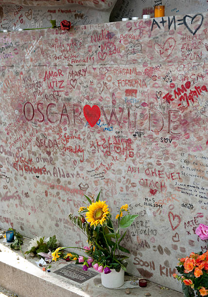 Tomb of Oscar Wilde "Paris, France - July 25, 2011:  The tomb of Oacar Wilde a famous Irish writer and poet is adorned with kisses and grafitti by fans. His tomb is located at Pere Lachaise Cemetery, Paris, France." oscar wilde stock pictures, royalty-free photos & images