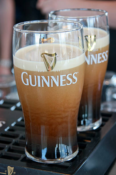 Two pints of beer served at The Guinness Brewery "Dublin, Ireland - June 19, 2008: Two pints of beer served at The Guinness Brewery, founded by Arthur Guinness in 1759, where 2.5 million pints of stout are brewed daily." guinness photos stock pictures, royalty-free photos & images