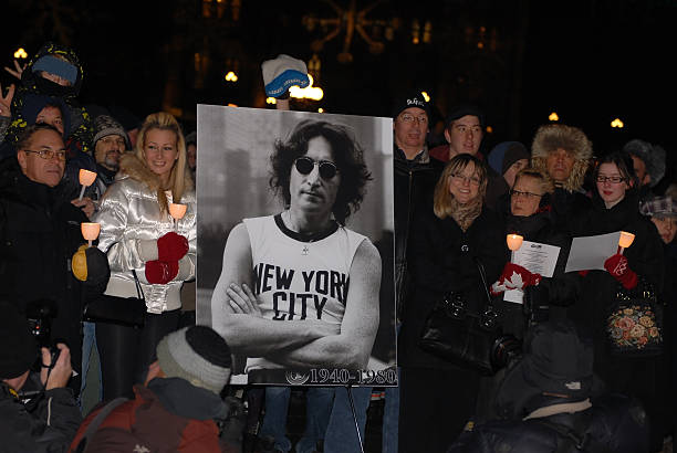 Fans gather to honor John Lennon "Ottawa, Canada - December 8, 2010:  Fans gather at the centennial flame on Parliament Hill to sing Give Peace A Chance on the 30th anniversary of John Lennon\'s assassination.  Similar events were held worldwide." beatles stock pictures, royalty-free photos & images