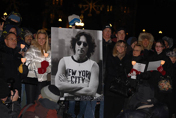Fans gather to honor John Lennon "Ottawa, Canada - December 8, 2010: Fans gather at the centennial flame on Parliament Hill to sing Give Peace A Chance on the 30th anniversary of John Lennon\'s assassination. Similar events were held worldwide." john lennon stock pictures, royalty-free photos & images