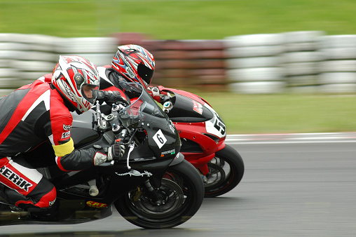 Poland, Poznan - June 18, 2007: Two young men riding a motorcycle in advanced level group, during the course of improving driving skills with motorcycle on the race track in Poznan.