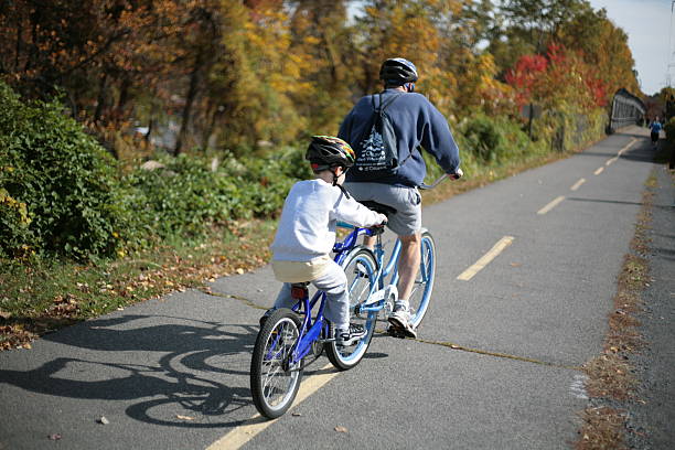 Father and son cycling together on a tandem bike stock photo