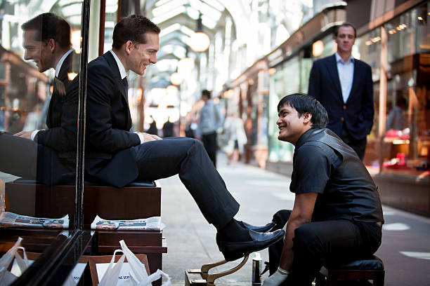 Business man having his shoes polished London, UK - May 4, 2011: Business man having his shoes polished by the shoe shine man in The Burlington Arcade shoe polish photos stock pictures, royalty-free photos & images