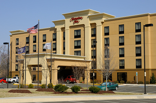 Warrenton, Virginia, USA - March 12, 2011: A newly opened Hampton Inn has several guests parked in the parking lot on a blue sky day.