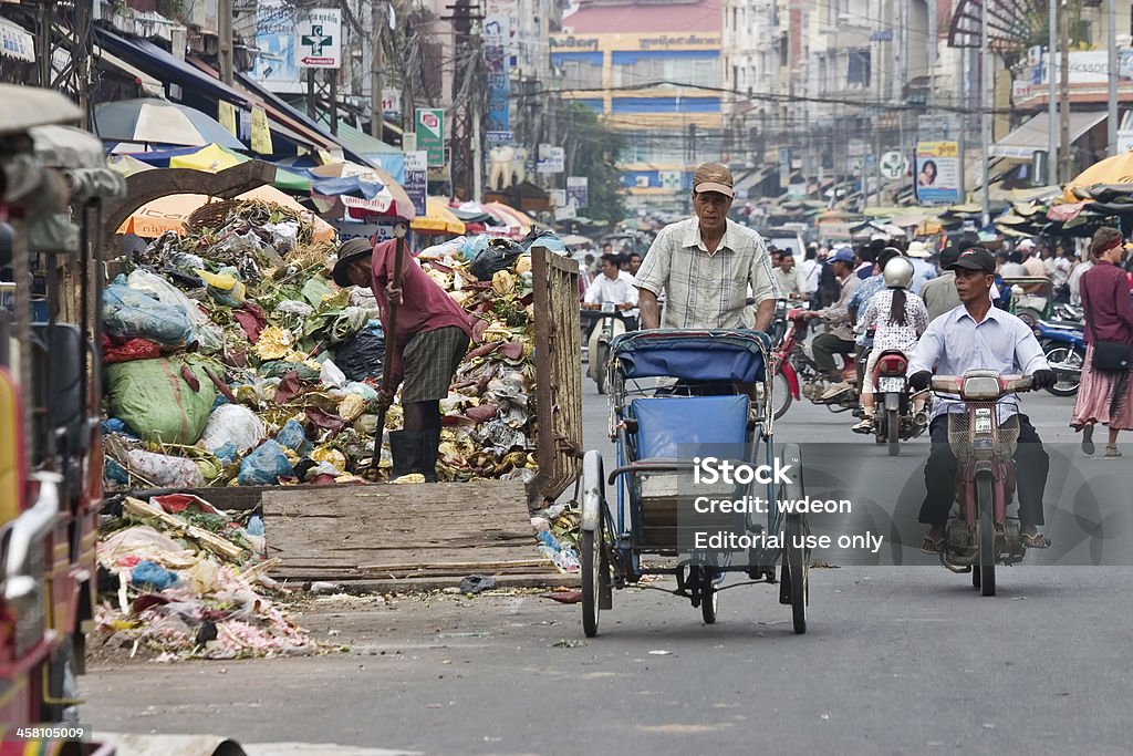 Camdodian cyclo driver przechodzi pojemnika na śmieci na Zajęty ulicy. - Zbiór zdjęć royalty-free (Kambodża)