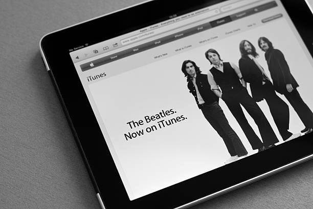 The Beatles now on iTunes Kiev, Ukraine - May 17, 2011: Apple Ipad shows iTunes home page with information that the Beatles music are now available for downloading.  beatles stock pictures, royalty-free photos & images