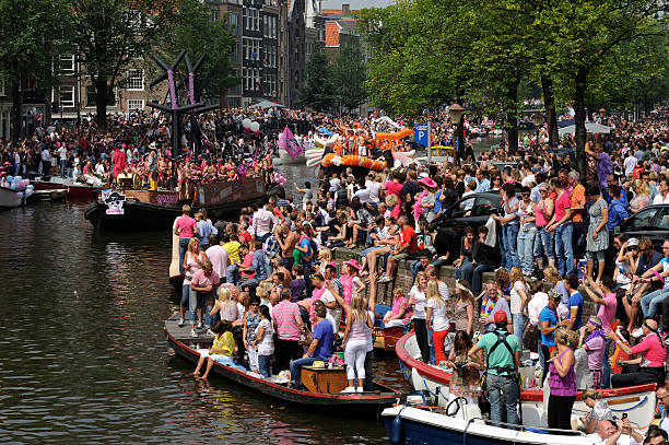 menschen der amsterdam kanal-parade - city amsterdam urban scene gay parade stock-fotos und bilder
