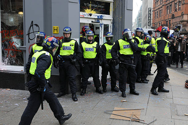 London, UK - November 24, 2010: A group of three Metropolitan police officers in the act of a stop and search on a young man involved in a demonstration march in London in which UK students made their opinions clear on the government funding cuts to education fees.