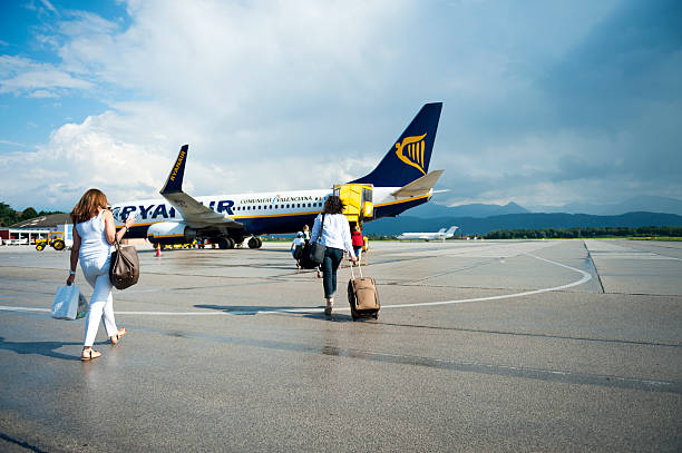 Travellers "Klagenfurt, Austria - August 11, 2012: Travellers, getting into the airplane. It is shot in summers at Klagenfurt airport." villach stock pictures, royalty-free photos & images